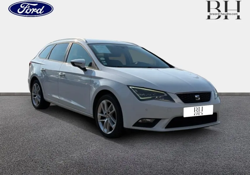 Vue 3/4 avant gauche d'une SEAT LEON ST blanche Candy avec jantes alu et barres de toit visibles.