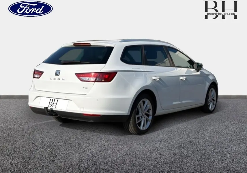 SEAT Leon ST blanc Candy vue 3/4 arrière droit avec crochet d'attelage et jantes alliage visibles.