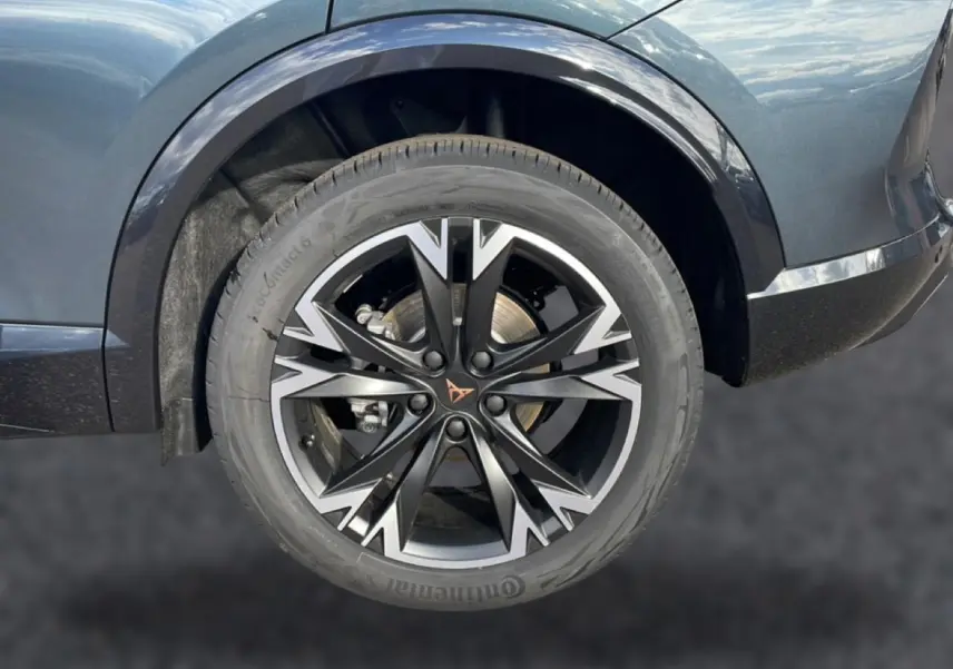 Gros plan sur la roue avant gauche du CUPRA Formentor gris magnétique avec jante noire et argentée au design distinctif.
