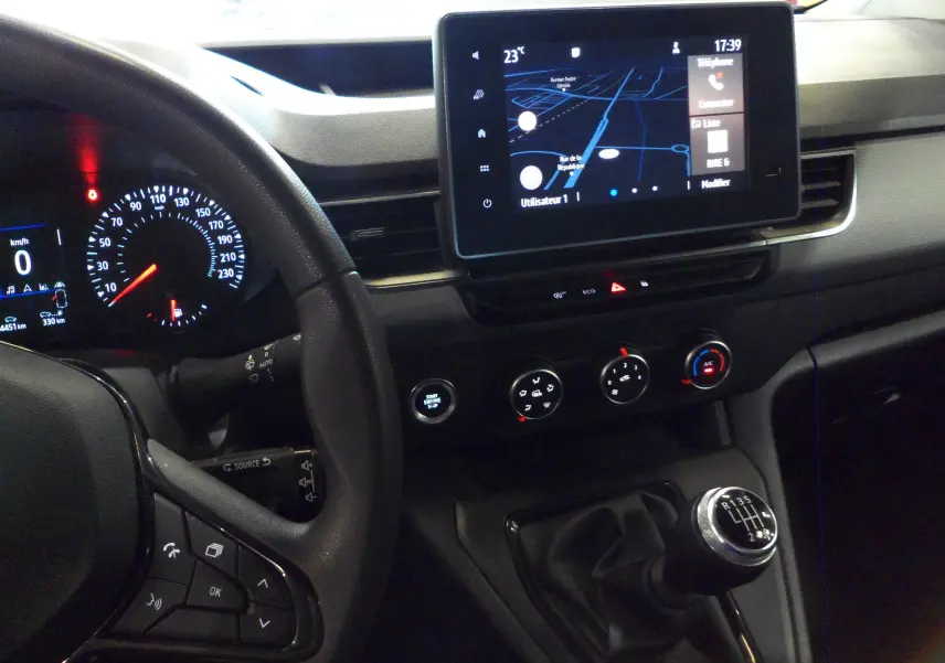 Intérieur du Renault Kangoo Van blanc, vue du tableau de bord avec écran tactile et levier de vitesse manuel visible.
