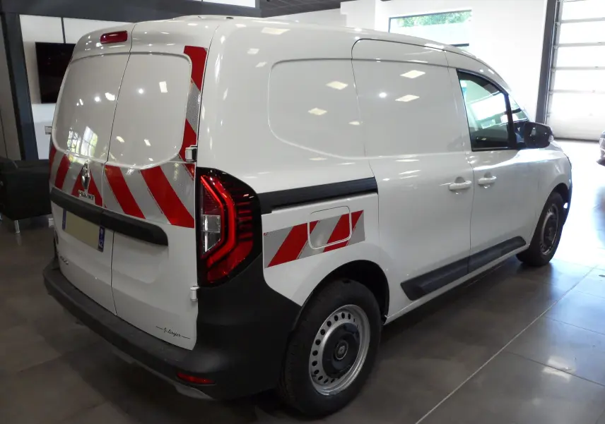 Vue 3/4 arrière droite du Renault Kangoo Van blanc minéral avec bandes réfléchissantes rouges et blanches sur les portes arrière et latérales.