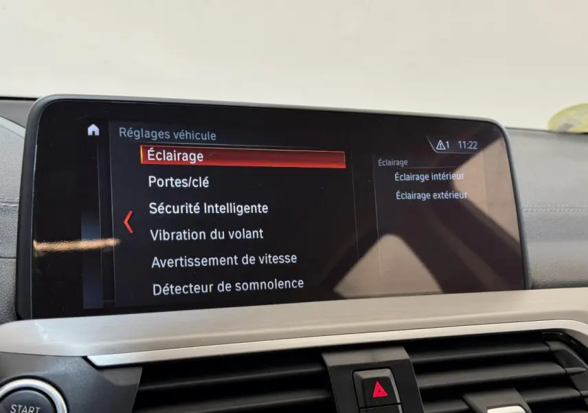Écran tactile du système de navigation BMW X3 xDrive30d 2018 affichant les réglages véhicule, vue intérieure frontale.