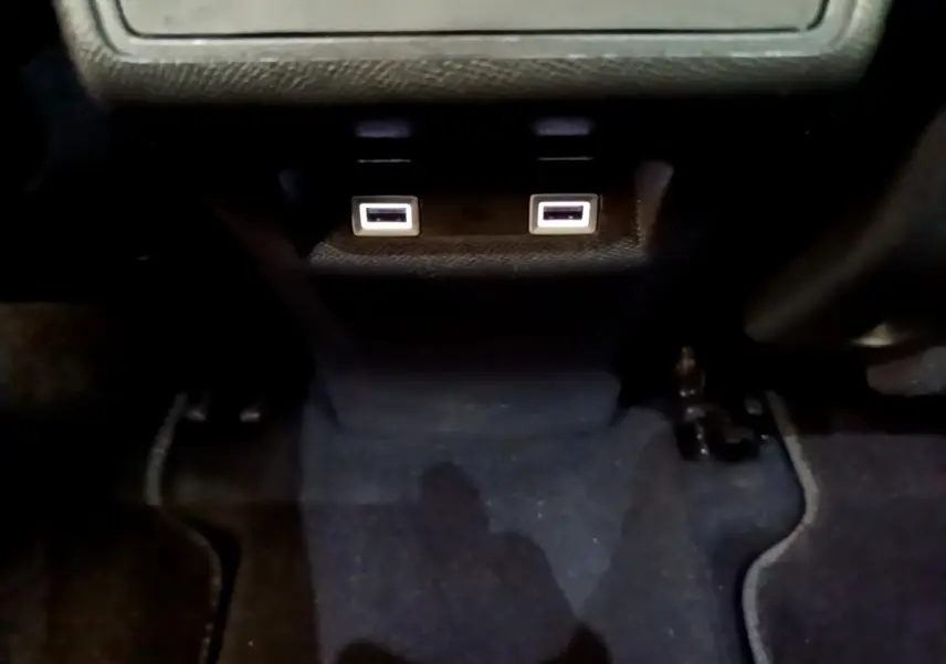 Vue intérieure rapprochée des ports USB doubles sous la console centrale du DS7 Crossback gris foncé.