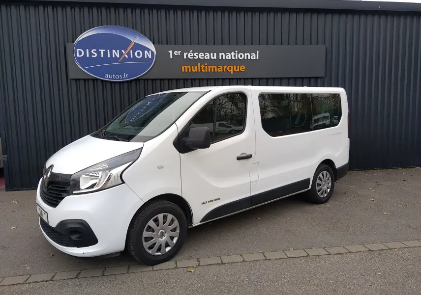 Renault Trafic Microbus blanc en vue 3/4 avant droit, avec vitres teintées et jantes acier.