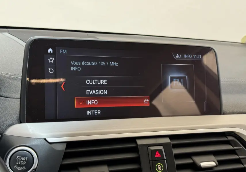 Écran tactile central affichant la radio FM dans l'habitacle gris clair d'une BMW X3 xDrive30d 2018.