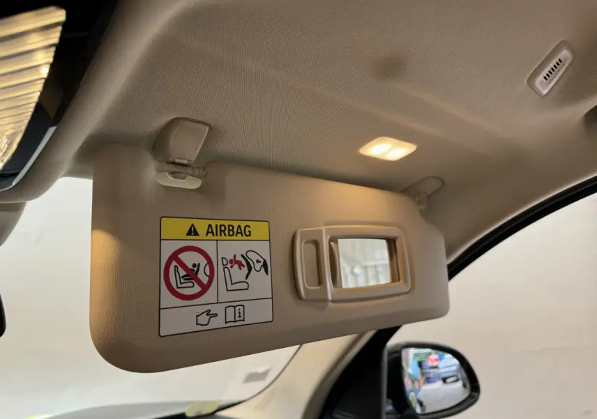 Détail du pare-soleil côté conducteur beige avec miroir éclairé dans l'habitacle d'un BMW X3 gris foncé 2018.