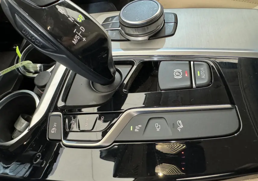 Gros plan sur la console centrale noire brillante du BMW X3 xDrive30d 2018 avec levier de vitesses automatique et commandes de conduite.