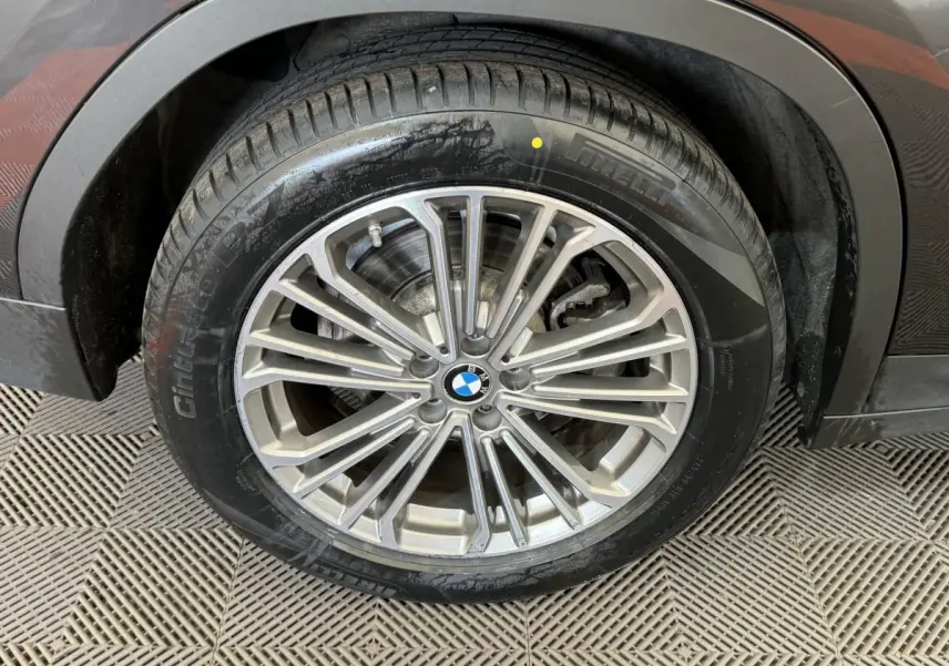 Gros plan sur la roue avant droite du BMW X3 gris foncé, mettant en valeur la jante alliage multi-branches et le pneu.