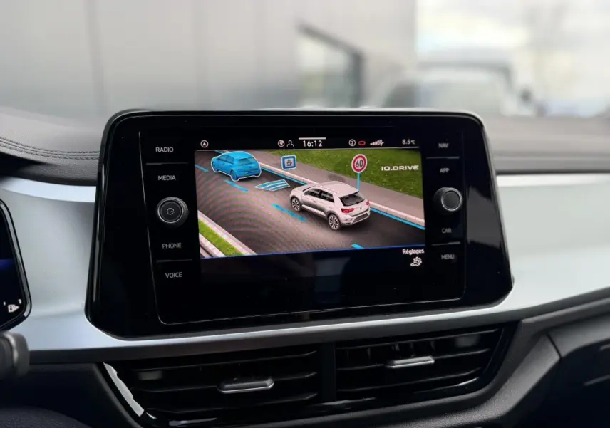 Écran tactile du tableau de bord du Volkswagen T-Roc 2025 affichant l'assistance à la conduite en ville.