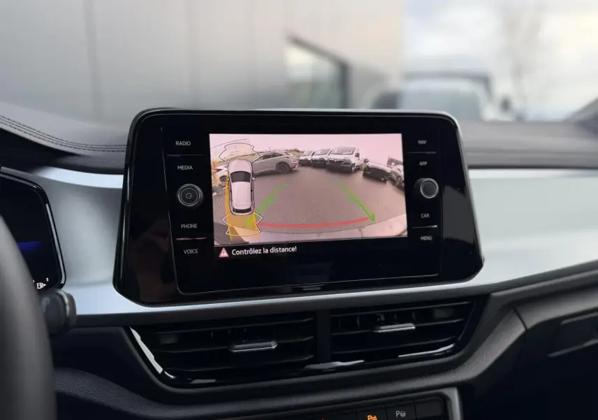Vue intérieure du tableau de bord du Volkswagen T-Roc 1.5 TSI 150 DSG Life 30 Years avec écran tactile affichant la caméra de recul.