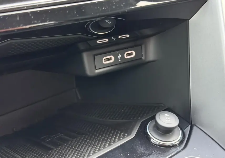 Gros plan sur la console centrale du Volkswagen T-Roc 2025, montrant prises USB-C et prise 12V noire.