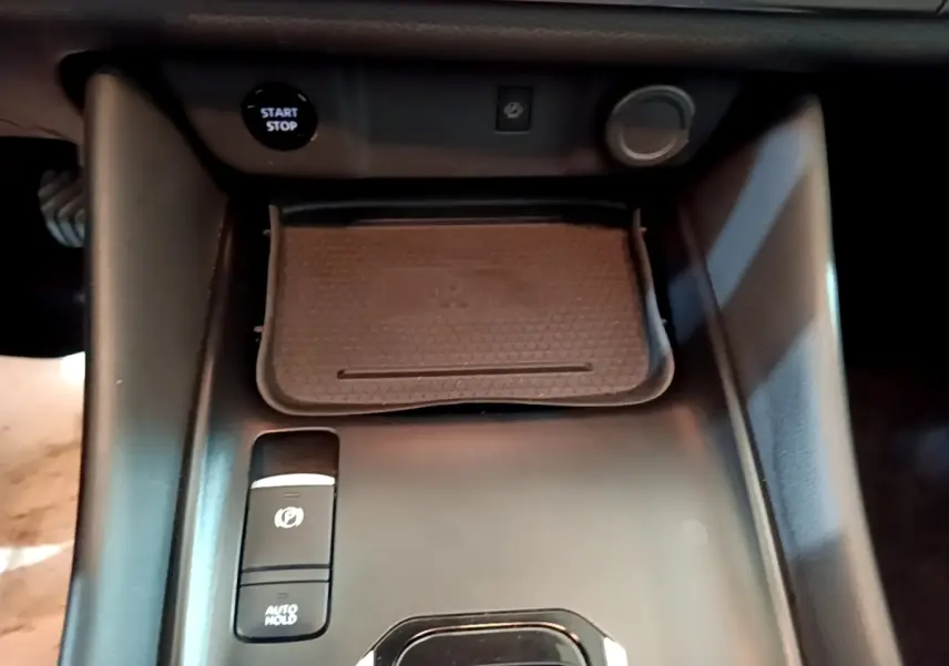Gros plan sur la console centrale noire du Nissan Qashqai e-Power 190 N-Connecta avec bouton start/stop et frein à main électrique.