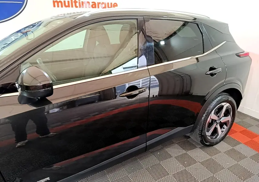 Vue de profil côté gauche du Nissan Qashqai e-Power noir, soulignant la ligne de chrome et les jantes alliage.
