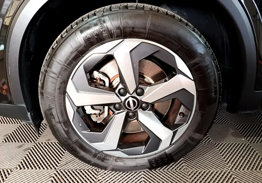 Gros plan sur la roue avant droite noire du Nissan Qashqai e-Power 190 N-Connecta avec jante alu bicolore.