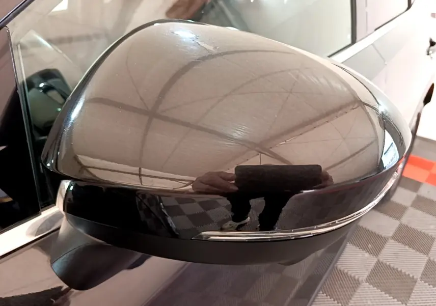 Gros plan sur le rétroviseur extérieur gauche noir brillant du Nissan Qashqai e-Power 2023 avec clignotant intégré.