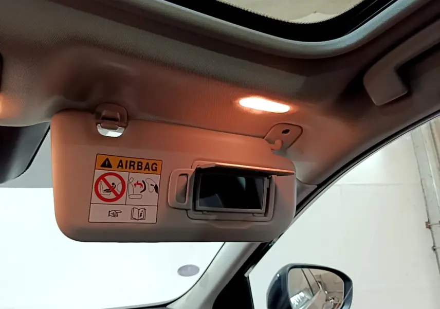 Détail intérieur du pare-soleil côté conducteur avec miroir éclairé du Nissan Qashqai e-Power noir 2023.