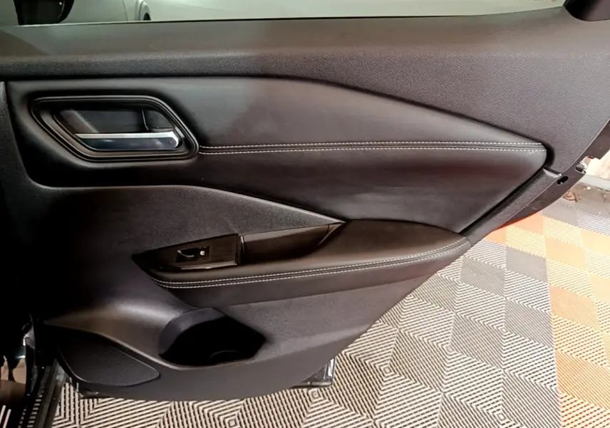 Vue rapprochée de la porte intérieure côté gauche noire du Nissan Qashqai e-Power 190 N-Connecta avec surpiqûres blanches.