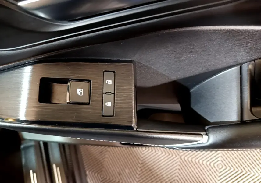 Gros plan sur les commandes de verrouillage et lève-vitre côté conducteur du Nissan Qashqai e-Power noir, finition N-Connecta.