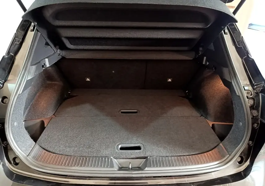 Coffre ouvert vu de l’arrière d’un Nissan Qashqai e-Power 190 N-Connecta noir avec banquette rabattue et intérieur sombre.