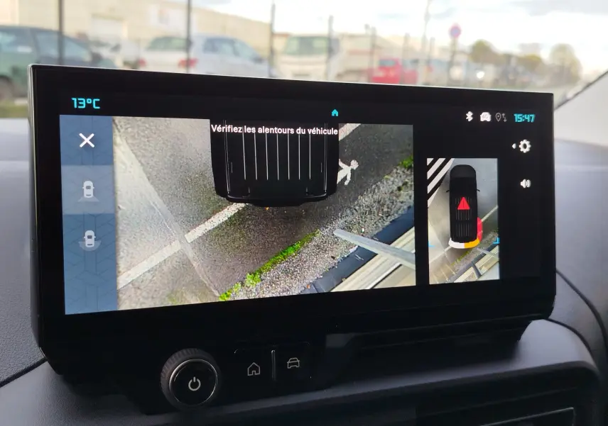 Écran intérieur du Citroën Berlingo Kaolin White 2025 montrant la caméra de recul avec vue aérienne du véhicule en stationnement.