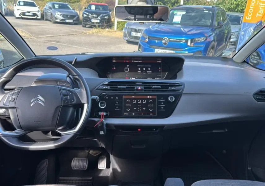 Vue intérieure avant du Citroën Grand C4 Spacetourer gris alu, avec tableau de bord numérique et volant multifonction cuir.
