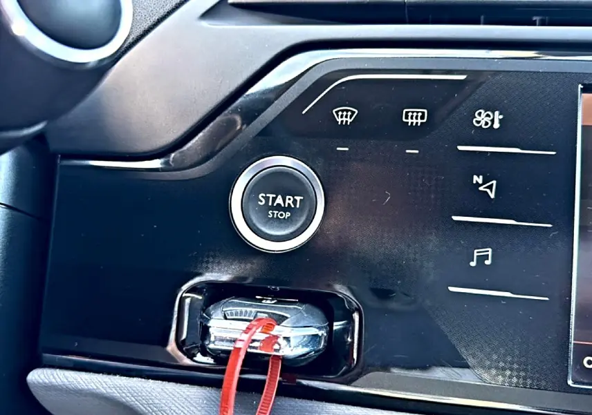 Gros plan sur le bouton start/stop et la clé insérée dans la console centrale noire du Citroën Grand C4 Spacetourer gris alu.