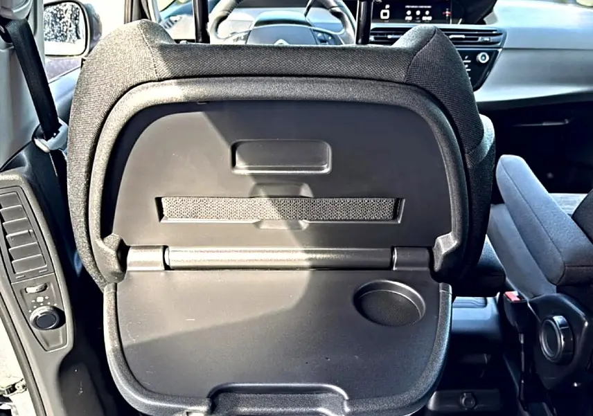 Dossier de siège arrière gris avec tablette rabattable et porte-gobelet, vue intérieure avant du Citroën Grand C4 Spacetourer.