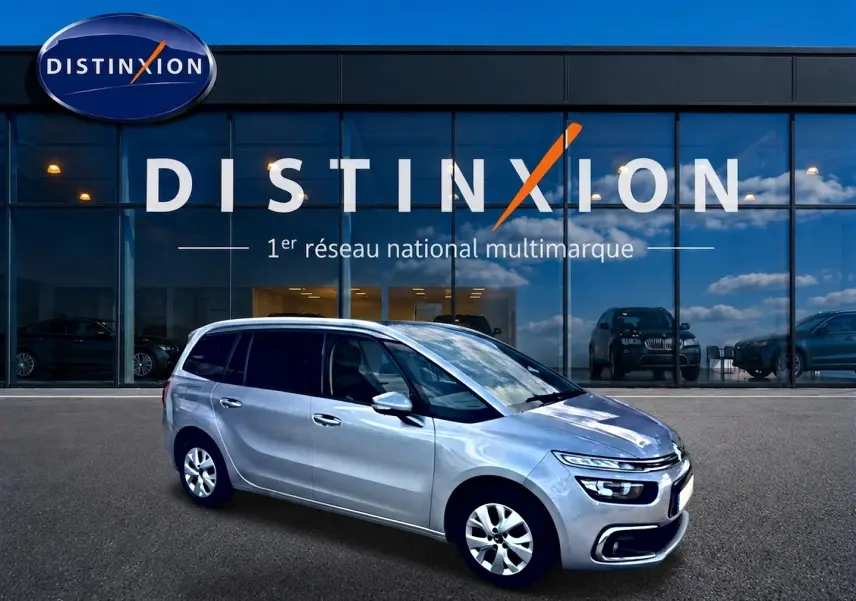 Citroën Grand C4 Spacetourer gris alu en 3/4 avant droit, avec jantes alu et vitres teintées, devant showroom Distinxion.