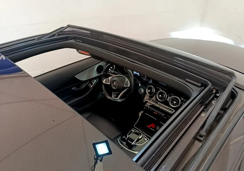 Vue plongeante sur l'intérieur noir d'une Mercedes Classe C Coupé 2018 avec toit ouvrant et tableau de bord moderne.