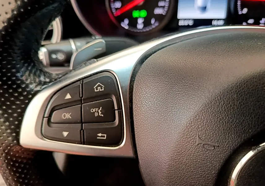 Gros plan sur les commandes gauche du volant en cuir noir du Mercedes Classe C Coupé C 220 d Fascination 2018.