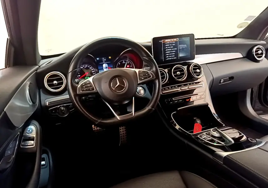 Vue intérieure avant de la Mercedes Classe C Coupé C 220 d Fascination 2018, tableau de bord noir avec écran central et volant multifonctions.