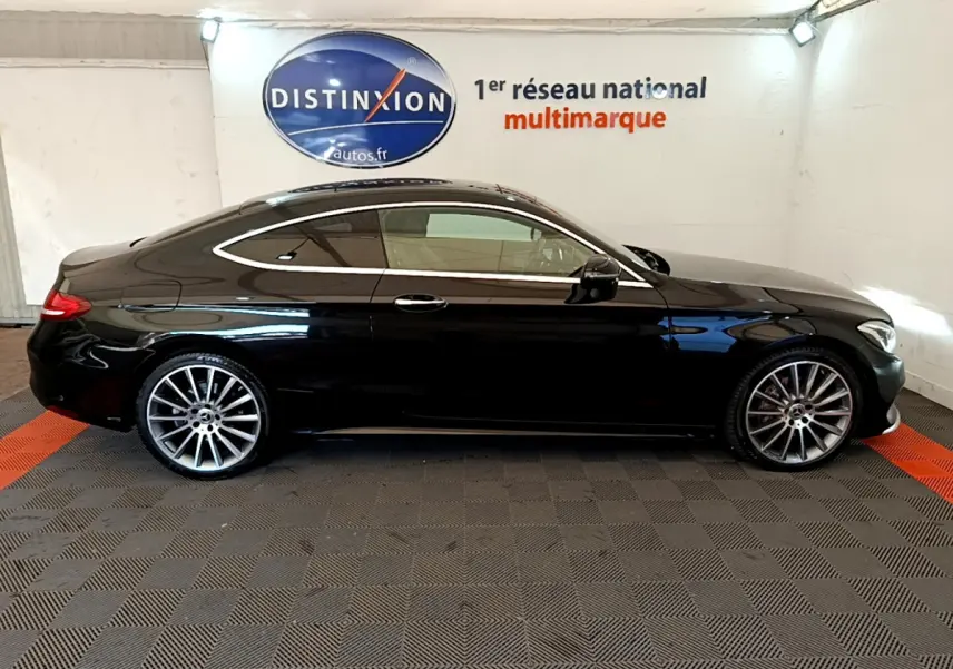 Profil côté gauche d'une Mercedes Classe C Coupé C 220 d Fascination noir brillant avec jantes alliage multibranches.