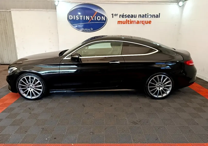 Profil côté gauche d'une Mercedes Classe C Coupé C 220 d Fascination noire, avec jantes alliage et lignes élégantes.