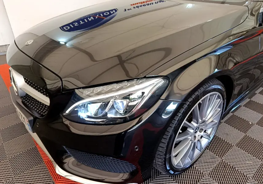 Gros plan sur l'avant droit noir brillant d'une Mercedes Classe C Coupé 2018 avec phares LED et jantes alliage.