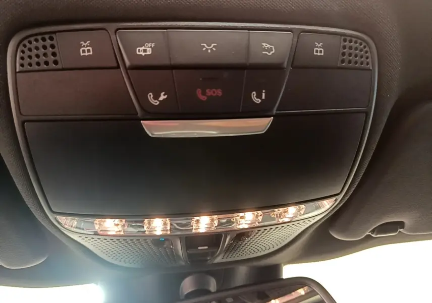 Vue en contre-plongée du panneau de commandes de plafonnier avec éclairage et boutons SOS dans l'habitacle de la Mercedes Classe C Coupé.