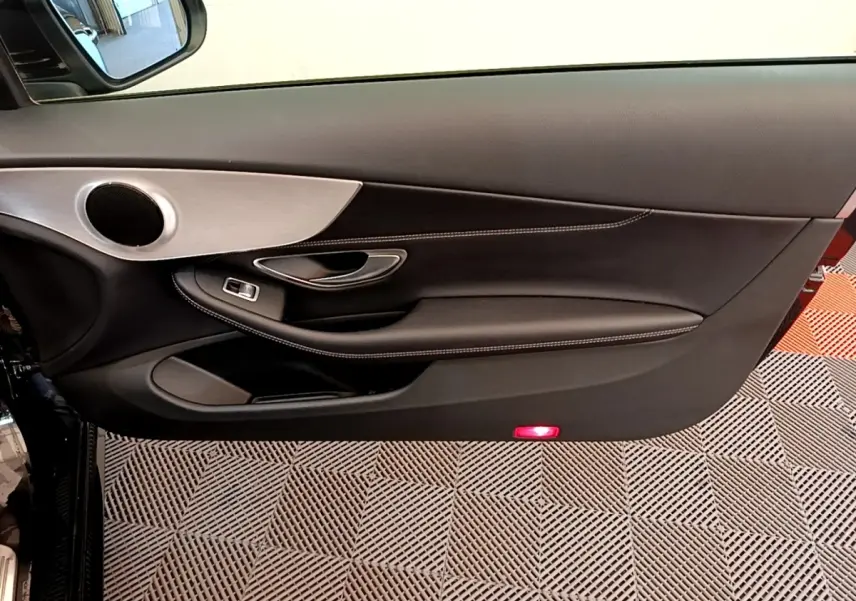 Intérieur montrant la porte côté gauche noire avec surpiqûres blanches et insert aluminium d'une Mercedes Classe C Coupé 2018.