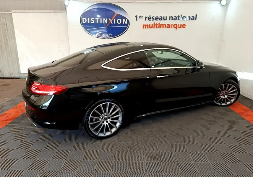 Mercedes Classe C Coupé C 220 d Fascination noir vue de profil côté gauche en intérieur showroom avec jantes alliage.
