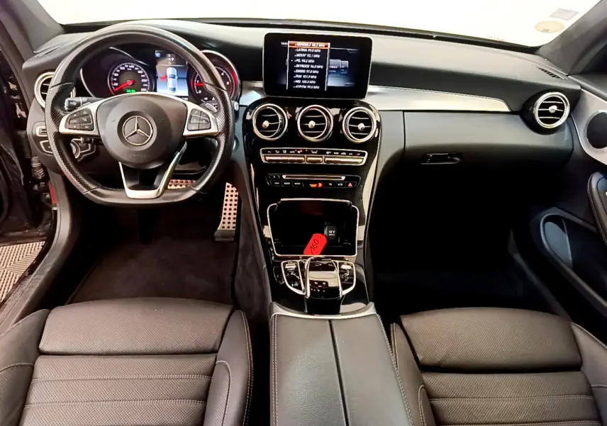 Intérieur noir de Mercedes Classe C Coupé 2018, vue frontale sur tableau de bord, volant cuir et écran central tactile.