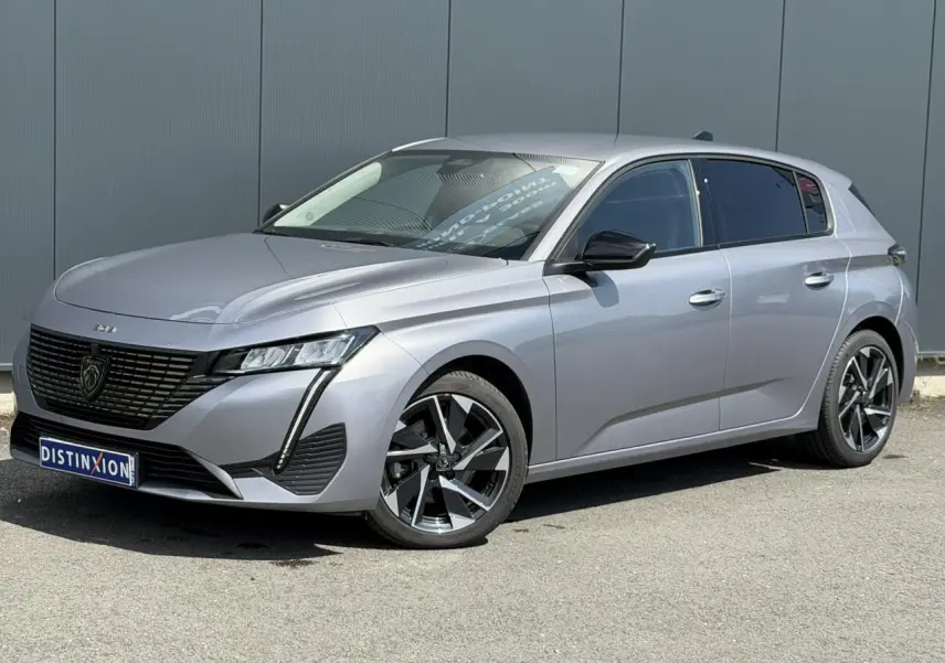 Peugeot 308 gris Artense vue 3/4 avant droit, jantes alliage 17'' et calandre noire distinctive.