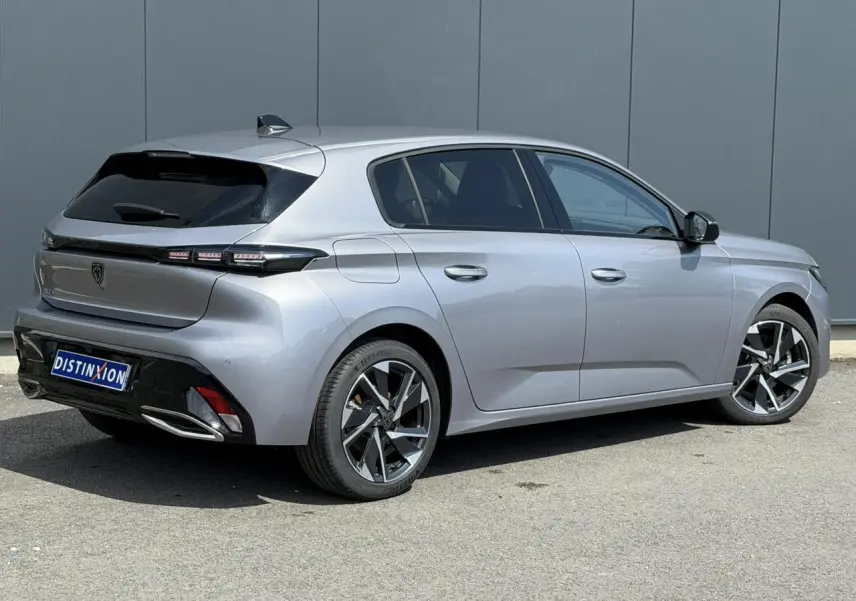 Peugeot 308 gris Artense vue 3/4 arrière droit, jantes alliage 17'' et bandeau noir brillant entre feux arrière.