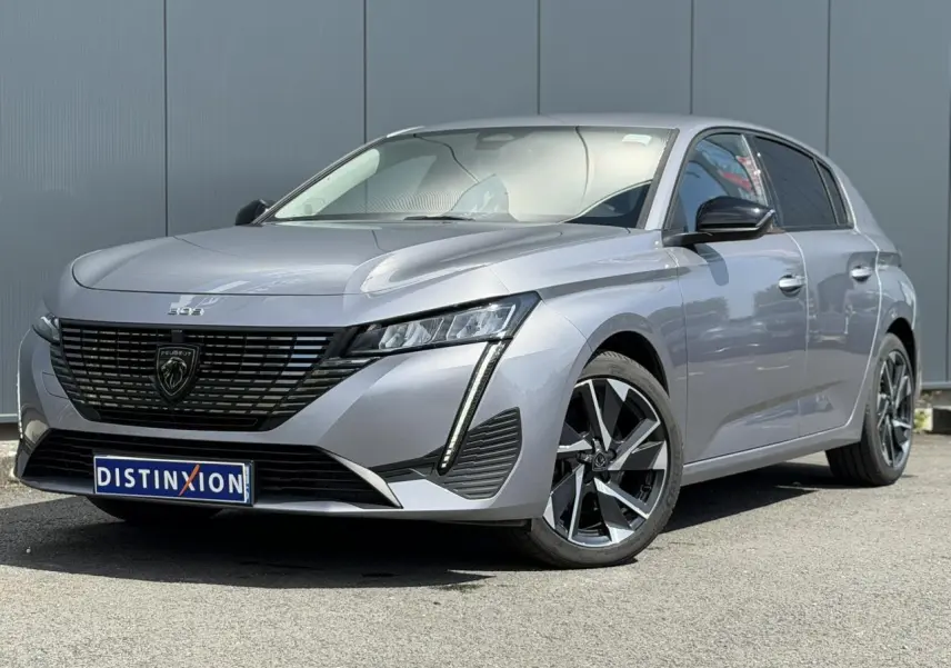Peugeot 308 gris Artense vue 3/4 avant droit, avec calandre noire et jantes alliage 17 pouces Halong diamantées.