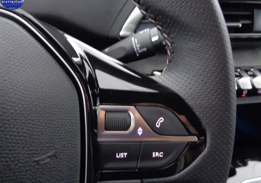 Gros plan sur les commandes gauche du volant en cuir perforé noir du Peugeot 3008 GT 2023, avec boutons lumineux.