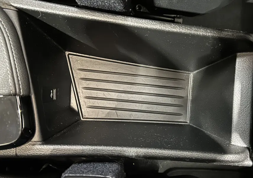 Gros plan sur le rangement central intérieur en plastique noir du BMW X1 sDrive 18D 2019, avec port USB visible.