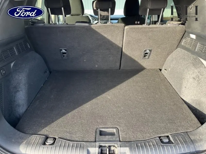 Coffre spacieux du Ford Kuga 2.0 EcoBlue 2020, vue arrière avec banquette arrière noire rabattue partiellement.