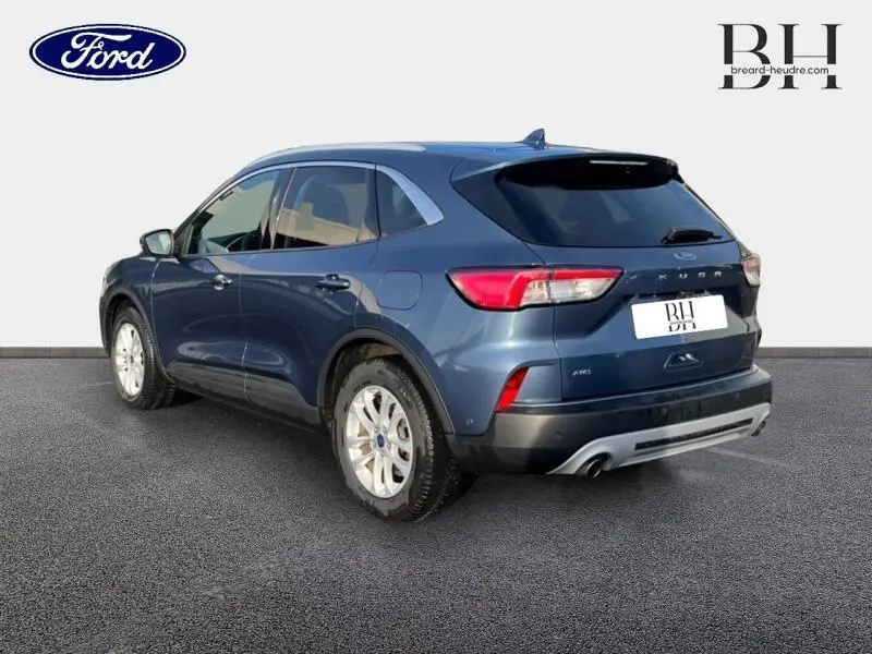 Vue 3/4 arrière droite d'un Ford Kuga 2020 bleu azur métallisé avec jantes alu et feux arrière LED distinctifs.