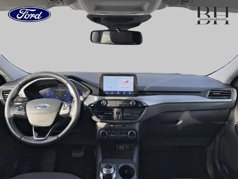 Vue intérieure du tableau de bord du Ford Kuga 2020 avec écran tactile central et volant multifonction noir.
