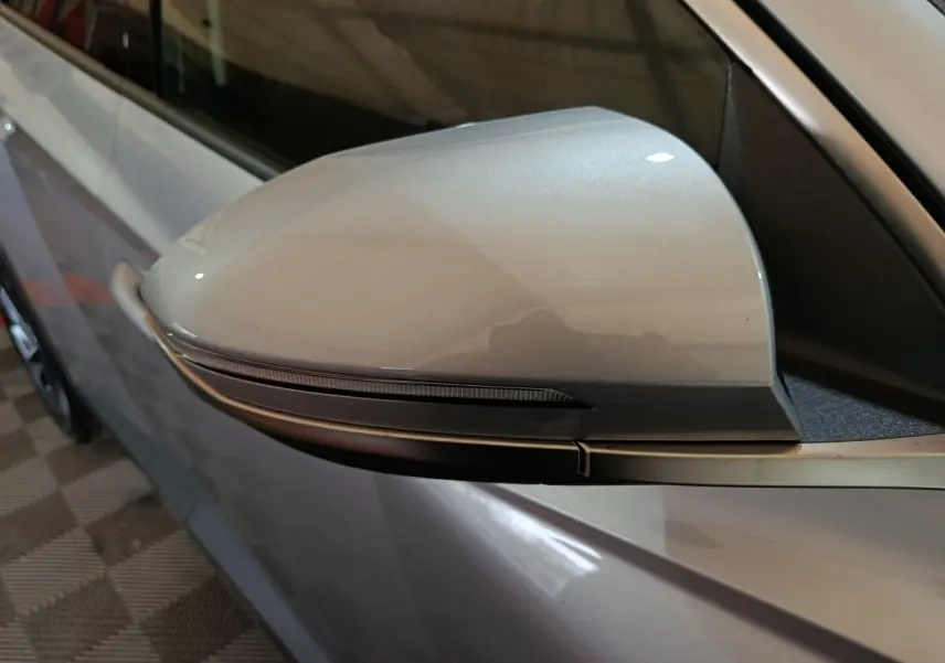 Gros plan sur le rétroviseur droit gris clair du Hyundai Tucson 2025 avec clignotant intégré.