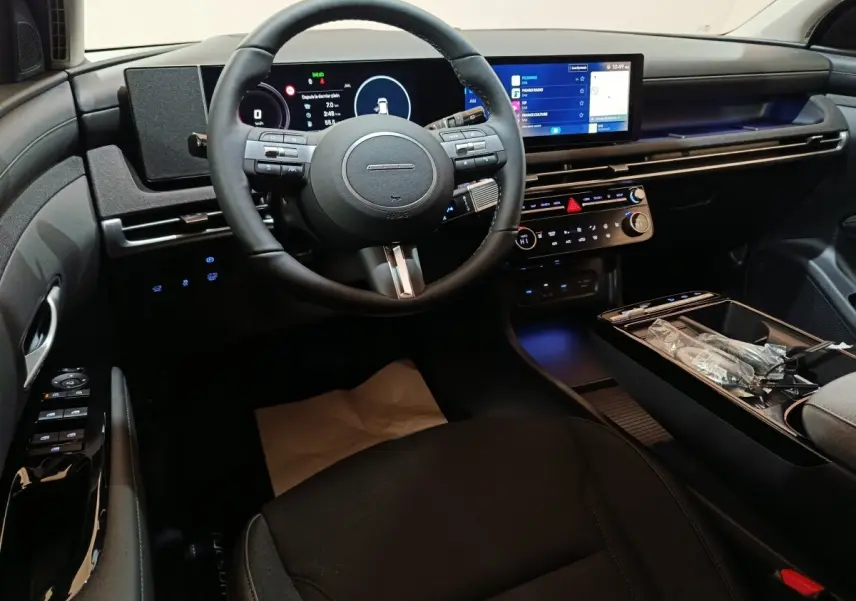 Vue intérieure côté conducteur du Hyundai Tucson 1.6 Hybrid 2025, tableau de bord numérique et écran tactile central.