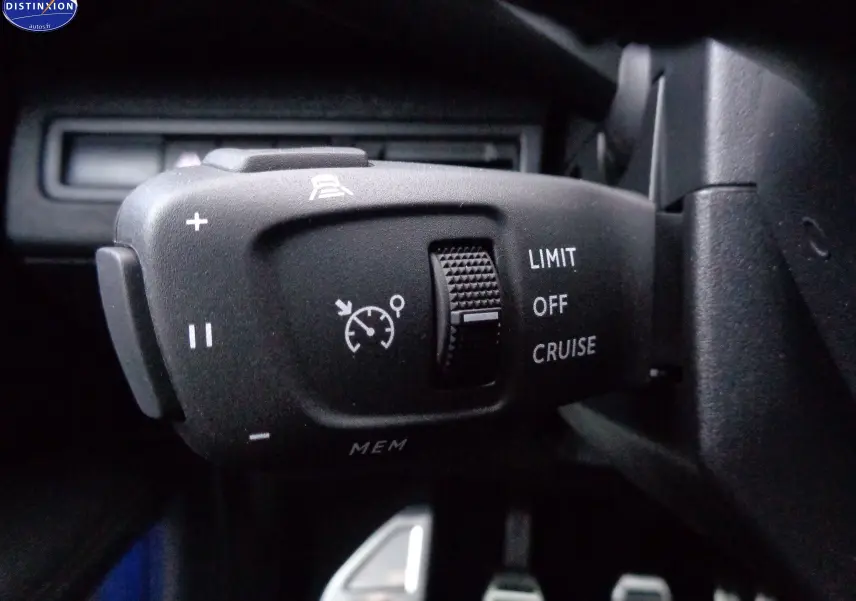 Gros plan sur la commande de régulateur de vitesse du Peugeot 3008 noir perle métal, côté gauche du volant.