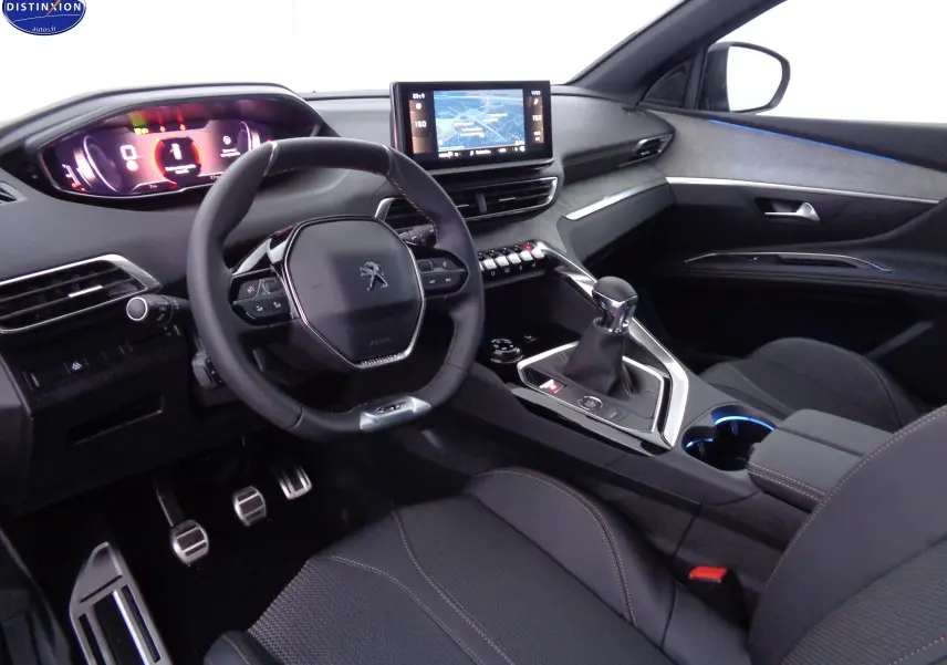 Intérieur noir du Peugeot 3008 2023, vue côté conducteur, volant compact, écran tactile et levier de vitesse manuel visibles.